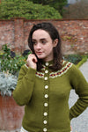 A girl in a green cardigan with a decorative yoke in three contrasting colours