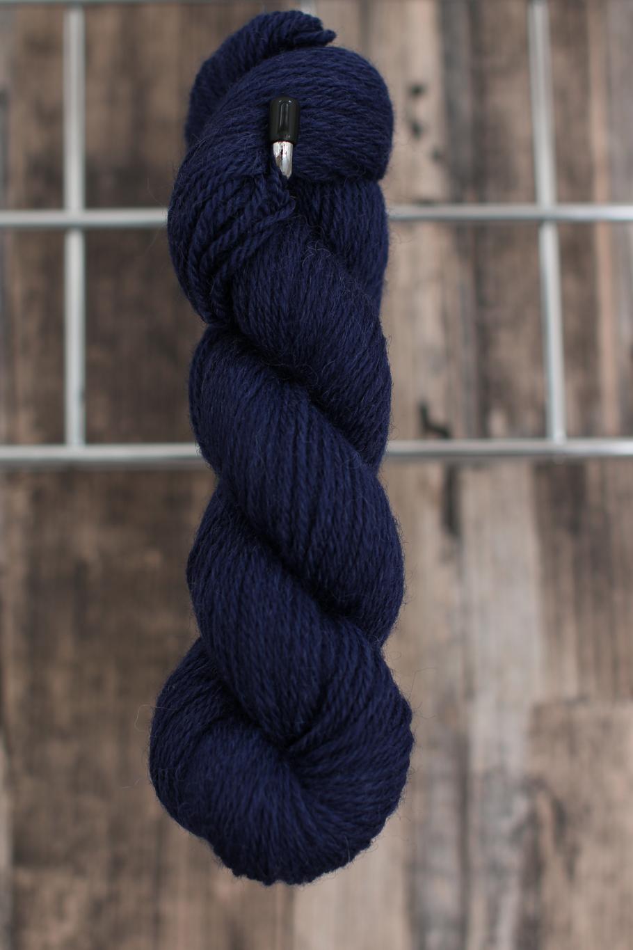 a single skein of dark blue wool hanging from a hook