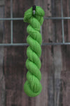 a skein of vibrant green wool hanging from a hook