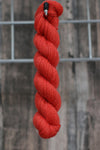 a single skein of red wool hanging from a hook