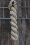 single skein of oatmeal wool hanging from a hook