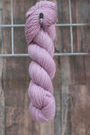 a single skein of lavender coloured wool hanging from a hook
