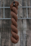 light brown skein of wool hanging from a hook