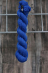 a skein of vibrant electric blue wool hanging from a hook