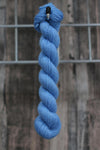 a skein of bright blue wool hanging from a hook