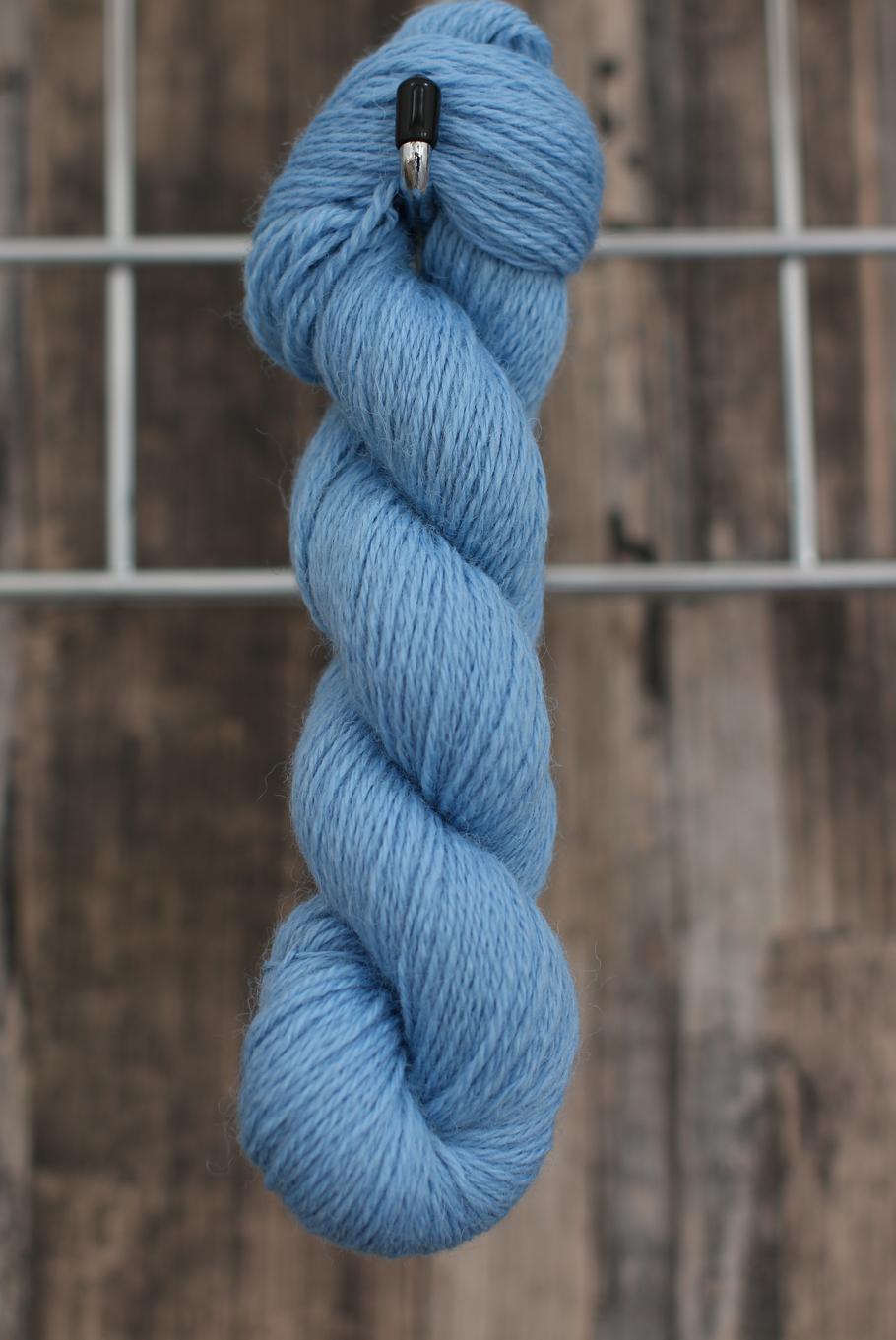 a bright blue skein of wool hanging from a hook