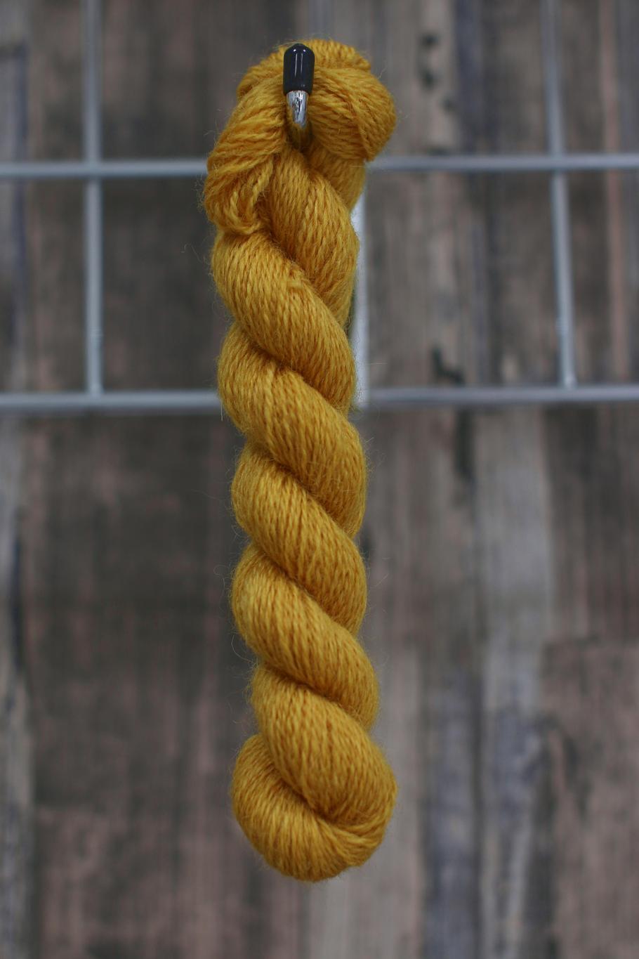 A golden skein of wool hanging from a hook