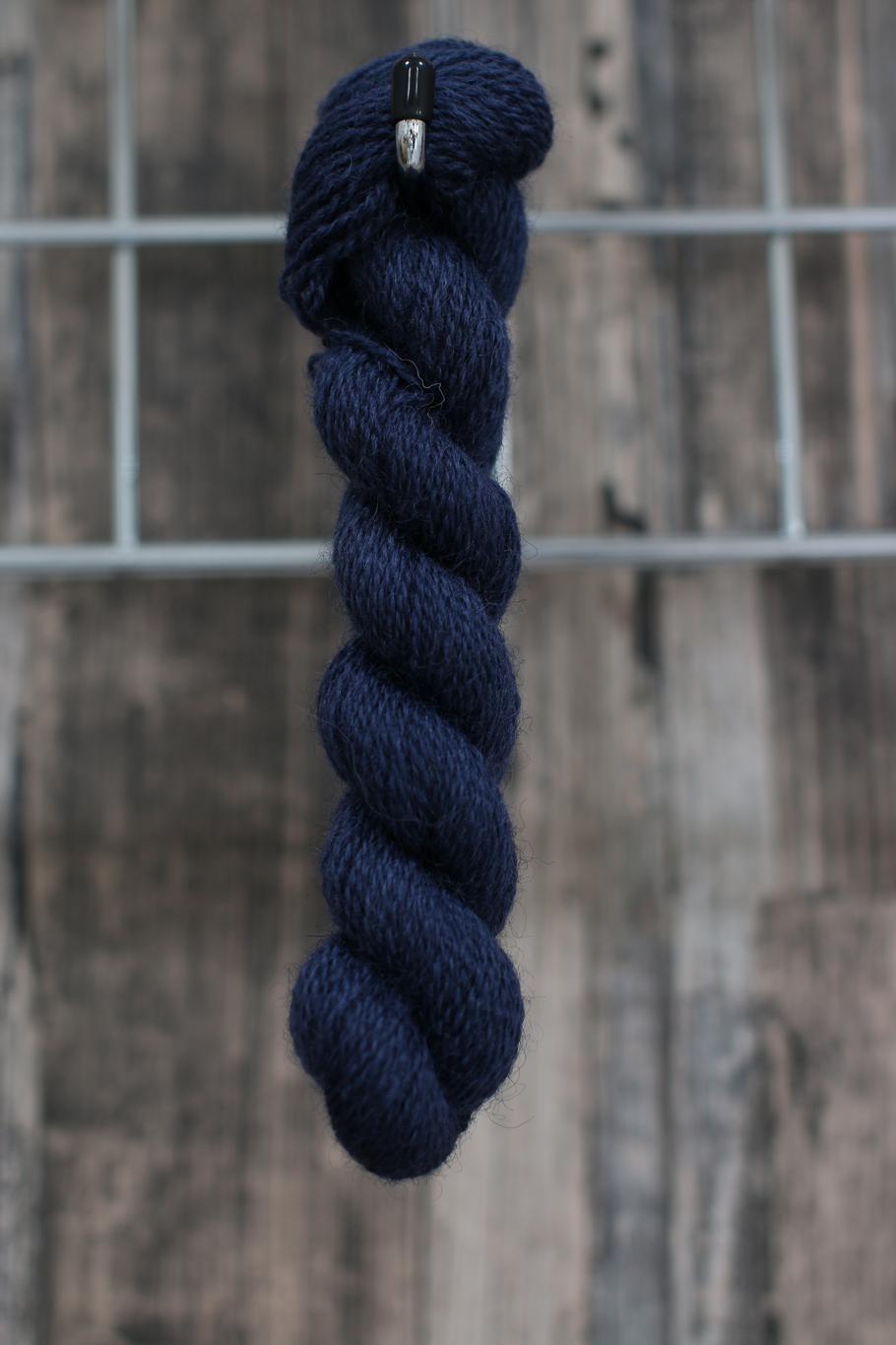 A Skein of dark blue wool hanging from  a hook