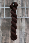 a rich brown skein of wool hanging from a hook