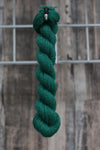 a dark green skein of wool hanging from a hook