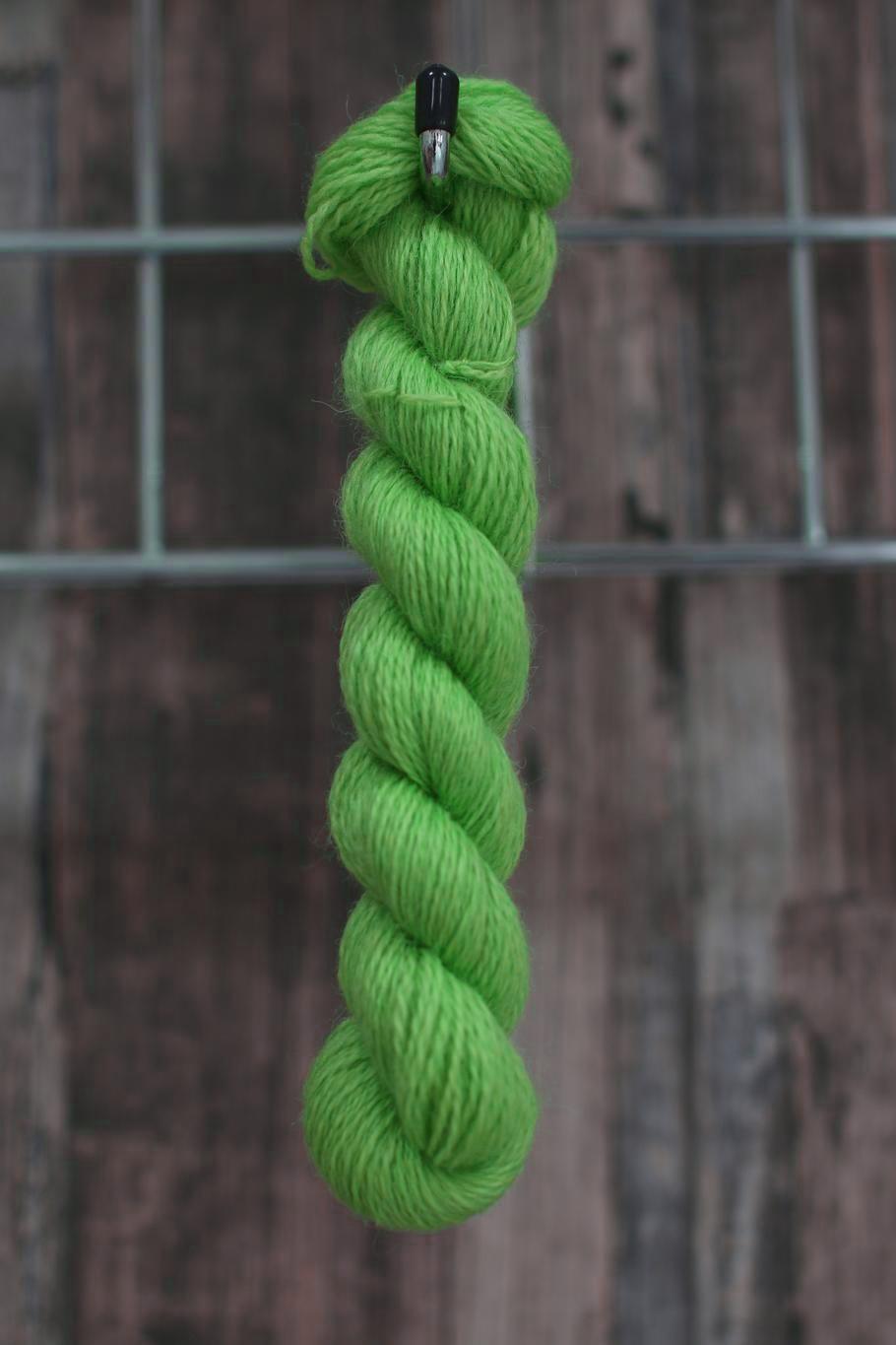 a skein of vibrant green wool hanging from a hook