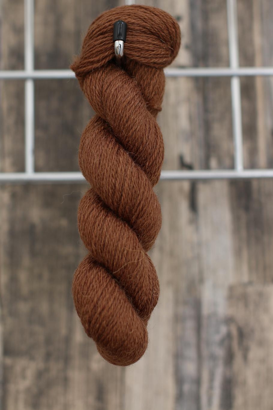 a warm brown skein of wool hanging from a hook