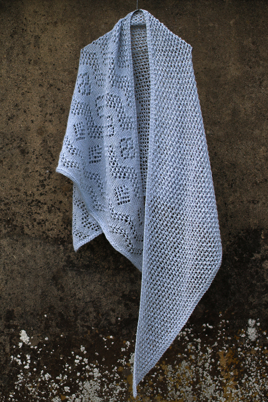 A lacy shawl hanging from a wall