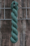 a blue-green skein of wool hanging from a hook