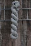 A light grey skein of wool hanging from a hook